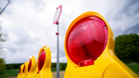 Das Straßenverkehrsschild Durchfahrt verboten hängt bei bewölktem und grauem Wetter an einer Straße vor einer Baustelle. 