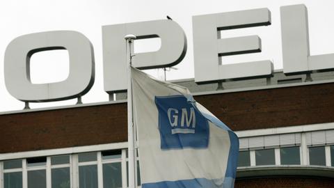 GM Fahne vor Opel-Firmenlogo