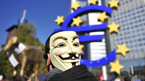 Protestler vor der Euro-Statue in Frankfurt