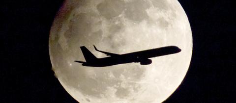 Flugzeug vor einem Vollmond