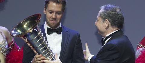 Sebastian Vettel erhält die WM-Trophäe von FIA-Präsident Jean Todt