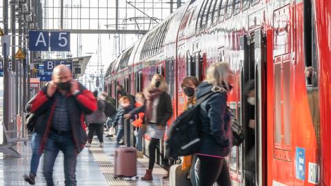 Menschen steigen ein und aus an einem Regionalzug im Frankfurter Hauptbahnhof.