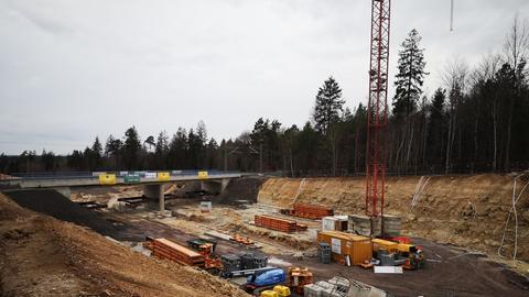 Brücke mit Schienen über Baustelle mit Fahrzeugen