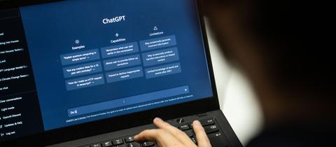Eine Person tippt auf einem Laptop in das Programm ChatGPT.