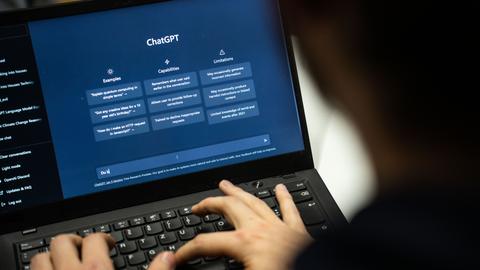 Eine Person tippt auf einem Laptop in das Programm ChatGPT.