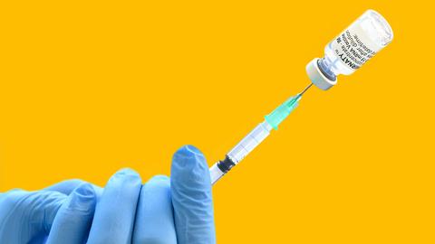 Corona-Spritze in Hand mit Impfdose