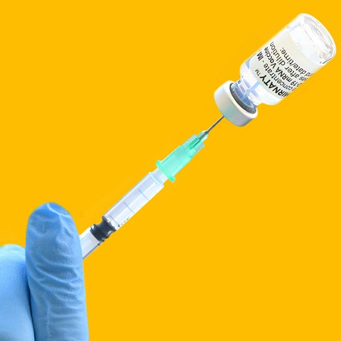Corona-Spritze in Hand mit Impfdose