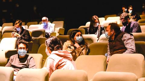 Kino-, Theatersitze mit wenigen Menschen mit Maske/Abstand 