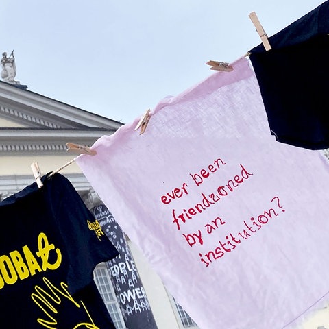 Beschriftete T-Shirts an der Leine aufgehängt vor dem Fridericianum in Kassel