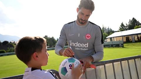 Trapp signiert Ball von jungem Fan