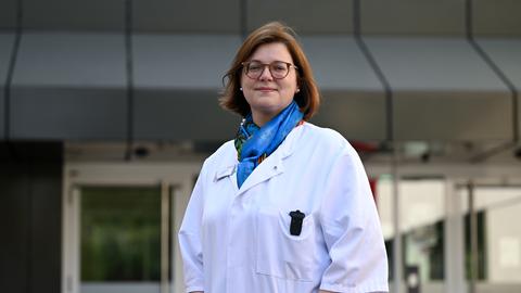 Erika Raab, in weißem Kittel vor dem Eingang der Kreisklinik Groß-Gerau