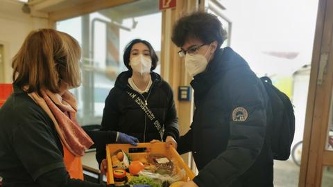 Die Ukrainer Serhii und Yevheniia Plugatirew holen eine Kiste mit Lebensmitteln bei der Tafel Gießen ab 
