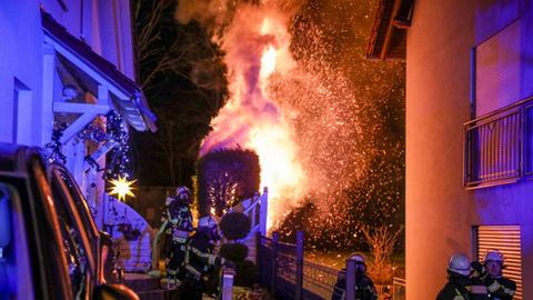 Die Feuerwehr löscht eine Hecke, die in der Silvesternacht in Brand geraten war.