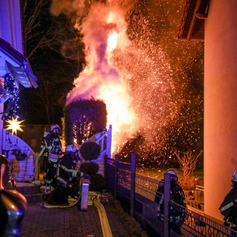 Die Feuerwehr löscht eine Hecke, die in der Silvesternacht in Brand geraten war.