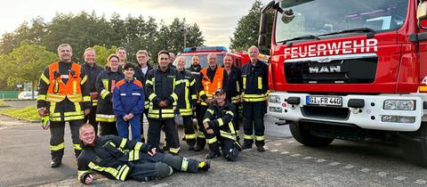 Die Truppe der freiwilligen Feuerwehr Rabenau-Mitte steht Schulter an Schulter und lächelt in die Kamera. 