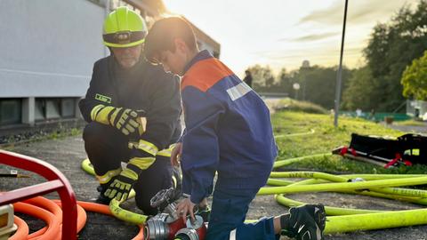 Siwar übt mit einem Kollegen das Aufdrehen des Löschschlauchs.