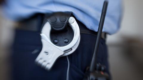 Blick auf die Handschellen eines Justizbeamten.