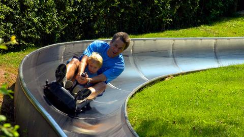 Vater mit Kind auf Sommerrodelbahn im Erlebnispark Steinau