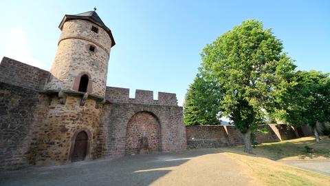 Der Teil einer alten Stadtmauer, darin ist ein Turm gebaut. Unten daran ist eine kleine Tür. 