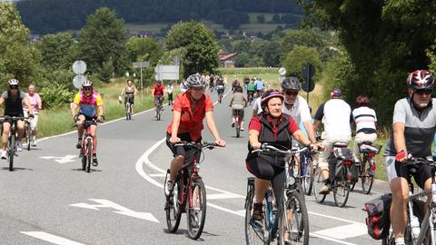 Fahrradfahrer und -fahrerinnen radeln auf einer für den Autoverkehr gesperrten Bundesstraße.