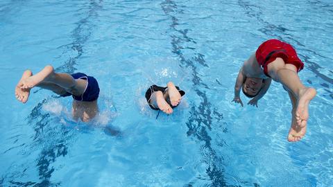 Kinder springen in ein Schwimmbecken