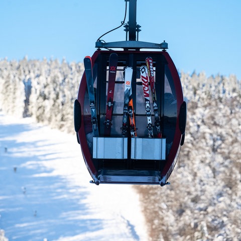 Skier sind an der Kabine der Ettelsberg-Seilbahn im Skigebiet Willingen befestigt. 