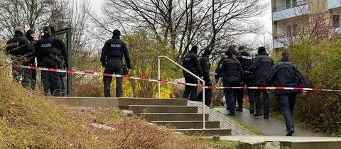 Polizeikräfte hinter Absperrband am Tatort am Aschenberg in Fulda.