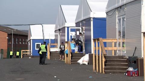Blaue Containerhallen mit Menschen