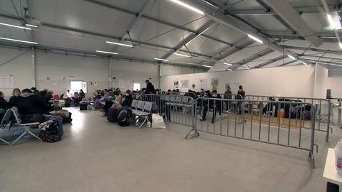 Menschen in einer Halle mit Plastikstühlen