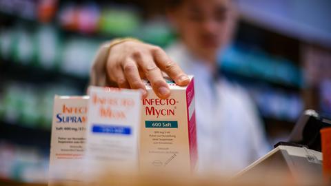 Ein Mitarbeiter einer Apotheke greift nach einer Packung Antibiotikasaft «Infectomycin» für Kinder. 