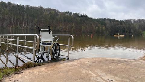 Barrierefreies Strandbad Twistesee. Am Steg steht ein wasserfester Rollstuhl.