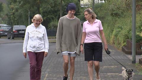 Ludmila, Jaroslaw und Svetlana laufen auf der Straße auf die Kamera zu.