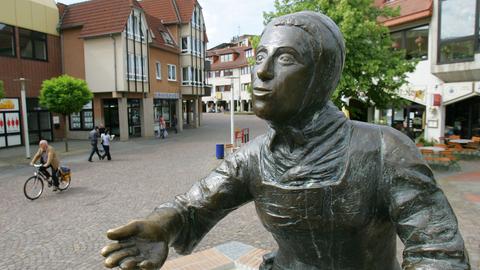 Märchenerzählerin Dorothea Viehmann blickt von einem Brunnen auf Baunatals Innenstadt