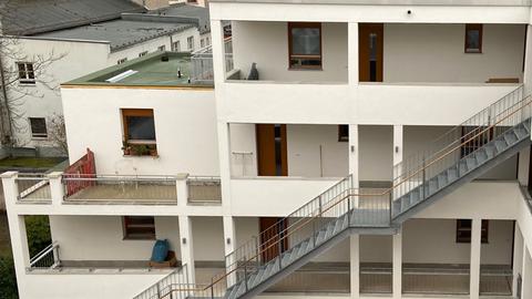 Die Laubengänge der weiß gestrichenen, modernen Wohnanlage mit Blick zum Innenhof