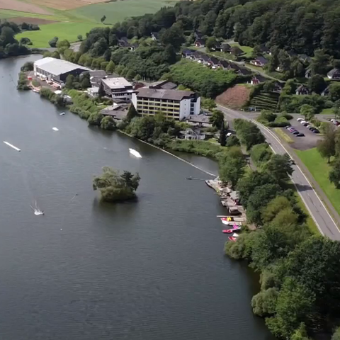 An einem See liegt ein Hotelkomplex, in dem Bhakti Marga ein Ashram eröffnet hat