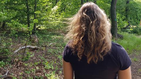 Frau mit wehenden Haaren von hinten