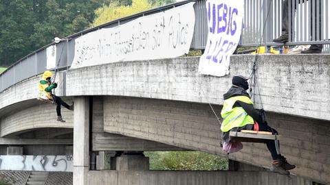 Zwei Aktivisten seilten sich von einer Brücke ab und spannen ein Transparent auf. 