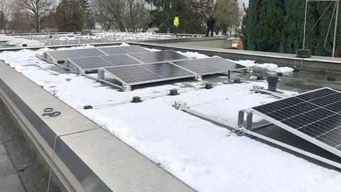 Solarmodule sind auf dem Dach der Schule, von Schnee bedeckt.