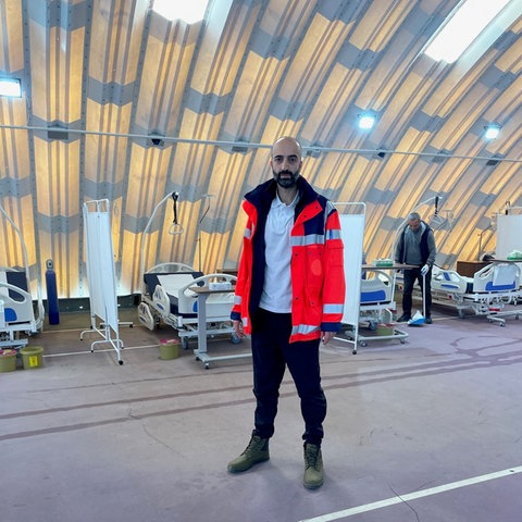 Cihan Çelik steht in einem Feldkrankenhaus in der türkischen Erdbebenregion. 