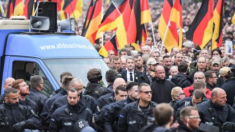 Demonstrationszug der AfD mit Deutschlandfahnen, mittendrin Björn Höcke in schwarzem Anzug und schwarzer Krawatte