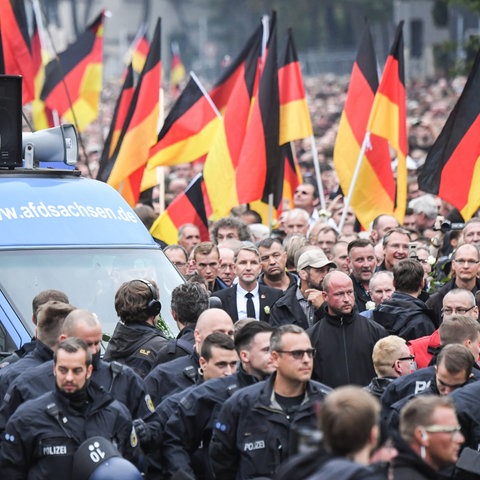 Demonstrationszug der AfD mit Deutschlandfahnen, mittendrin Björn Höcke in schwarzem Anzug und schwarzer Krawatte