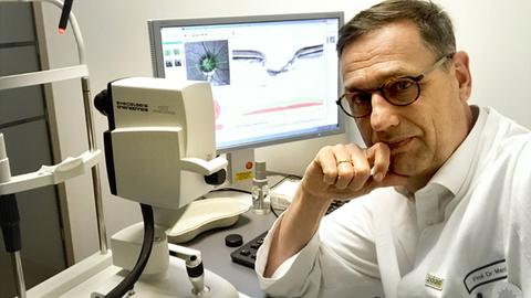 Professor Christian Mardin vor seinem Arbeits-PC in der Universitätsklinik Erlangen