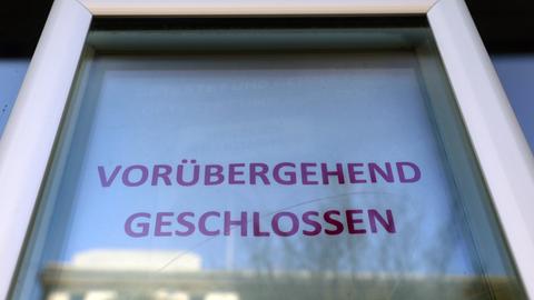 Vor einem Laden informiert ein Aushang "Vorübergehend Geschlossen".