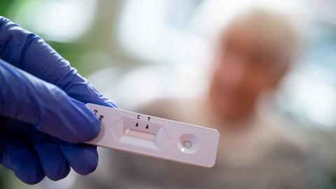 Eine Altenpflegerin hält einen Antigen-Corona-Schnelltest in der Hand.