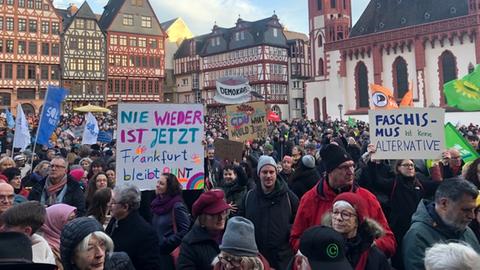 Menschen versammeln sich mit Transparenten am Frankfurter Römerberg zur Demo gegen Rechtsextremismus