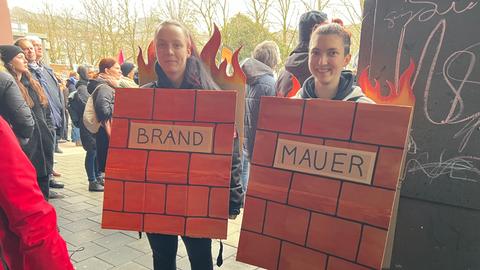 Demonstrantinnen in Darmstadt mit "Brandmauer"Schildern 
