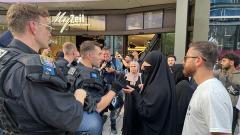Mehrere Polizeibeamte sprechen mit Teilnehmern einer pro-palästinensischen Demonstration auf der Frankfurter Zeil.