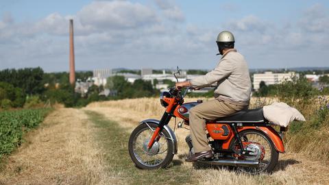 Ein Mann auf einem alten Motorrad blickt auf Groß-Umstadt
