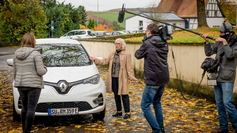 Dreharbeiten mit Frau vor Auto