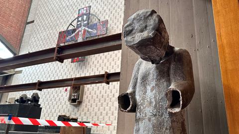 Eine Bronzefigur mit abgeschlagenen Händen vor einer Flatterleine
